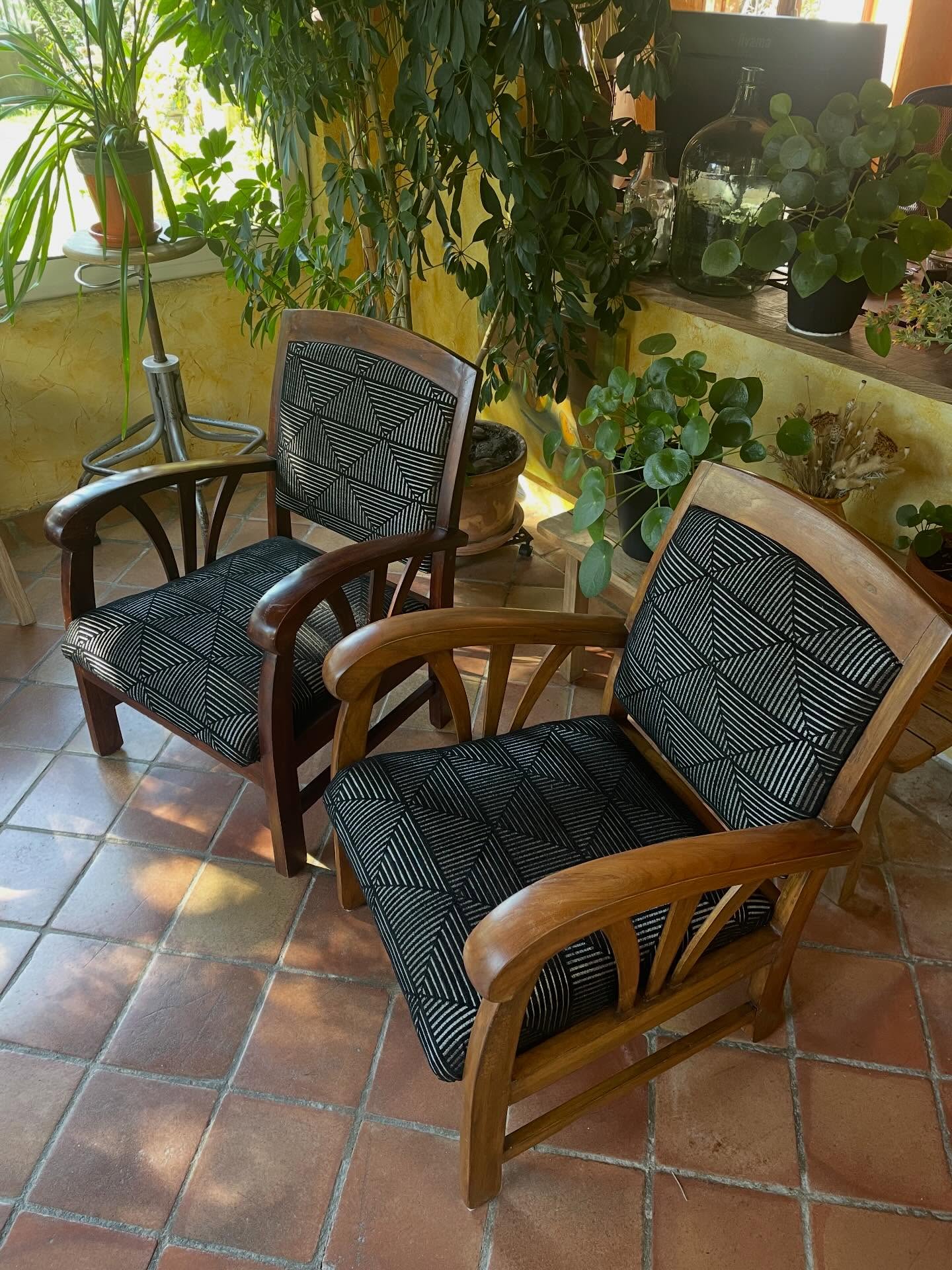 Deux fauteuils en bois exotique rénovés avec un tissu géométrique noir et écru