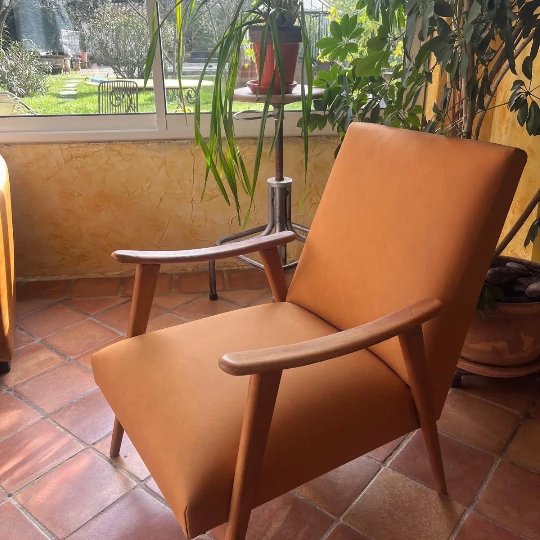 Fauteuil rénové avec des accoudoirs en bois et une assise et un dossier couleur ocre